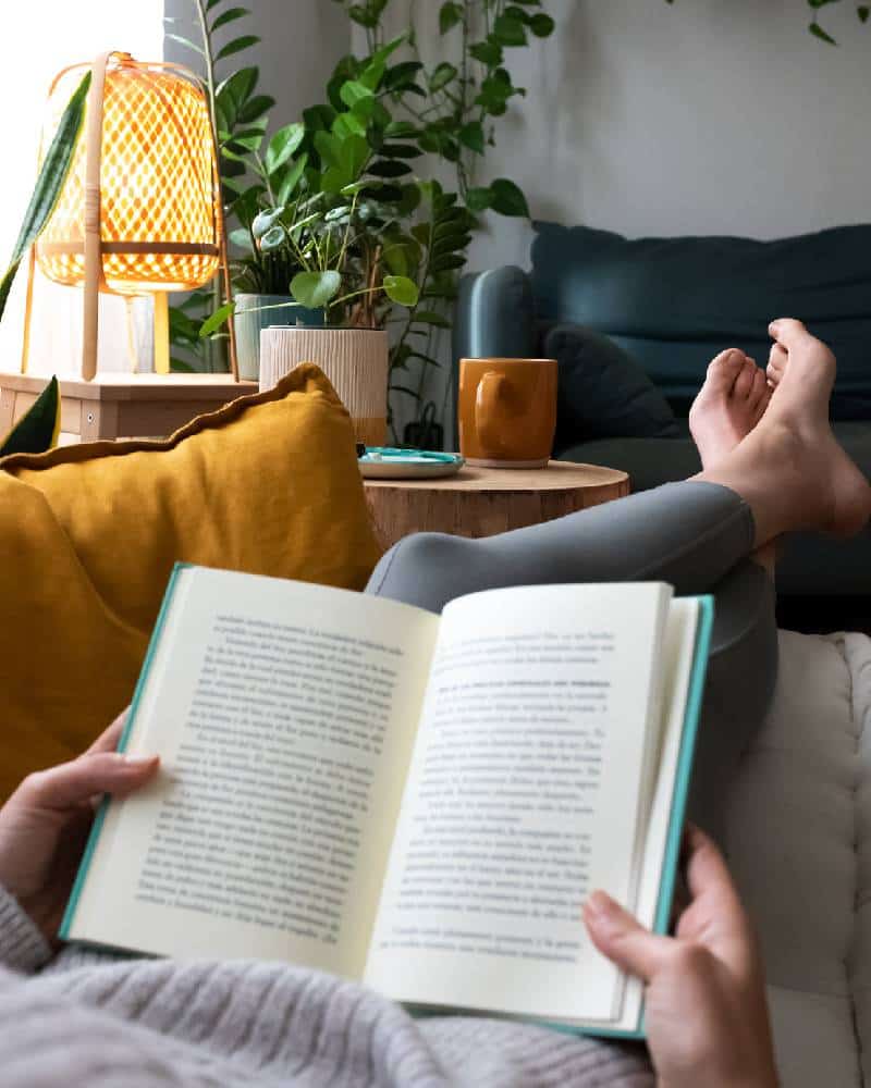 White women reading a book on the sofa
