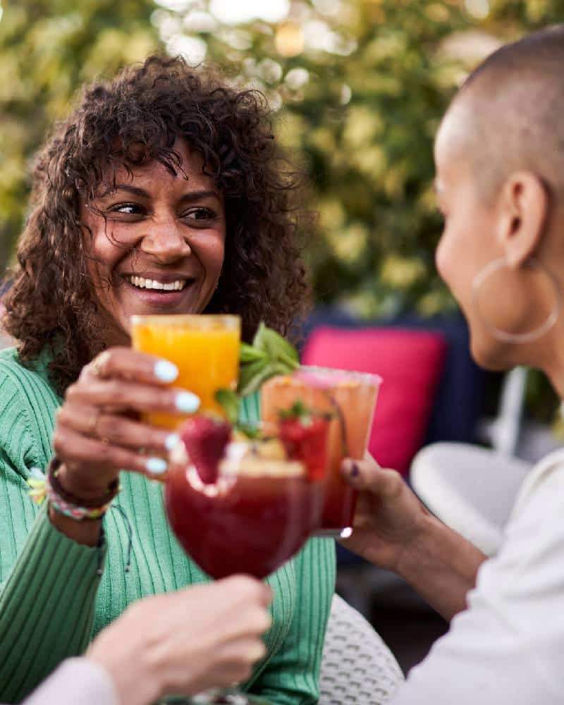 Two black women cheering cocktails