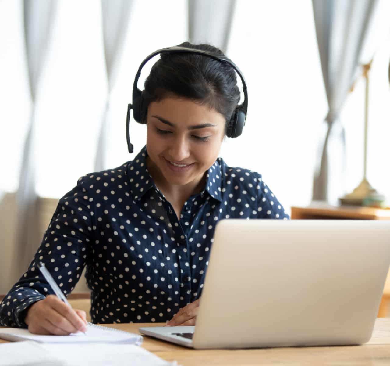 Indian girl student wear headset study online teacher write notes stock photo