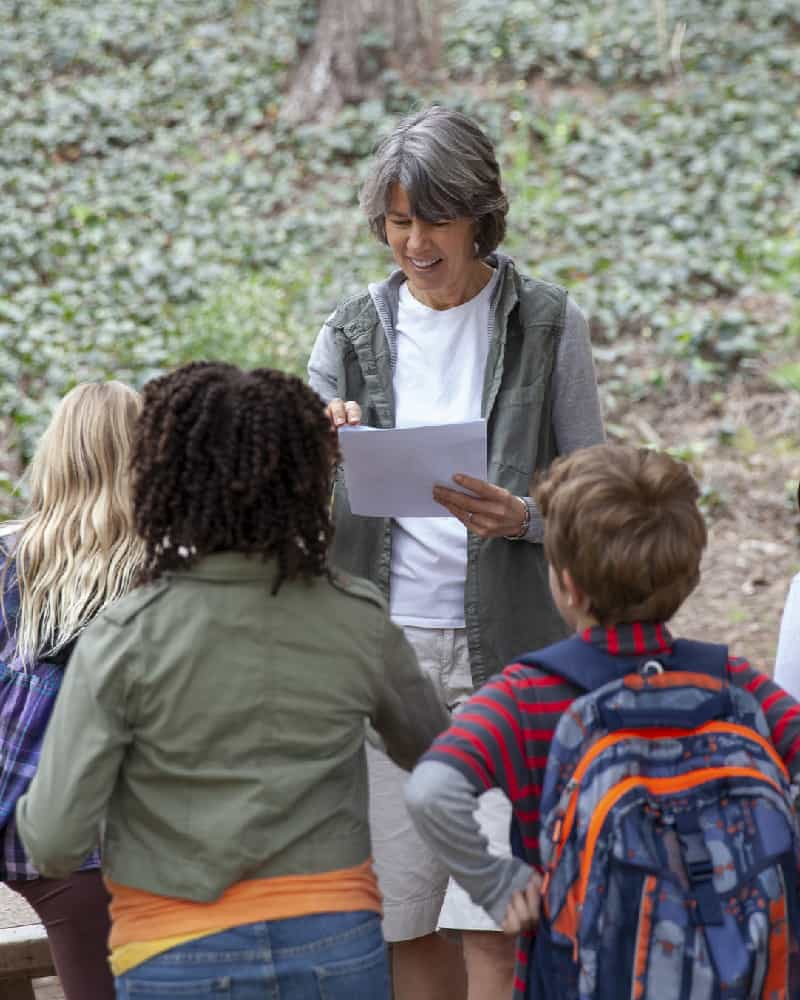 Teacher and students on field trip in woods