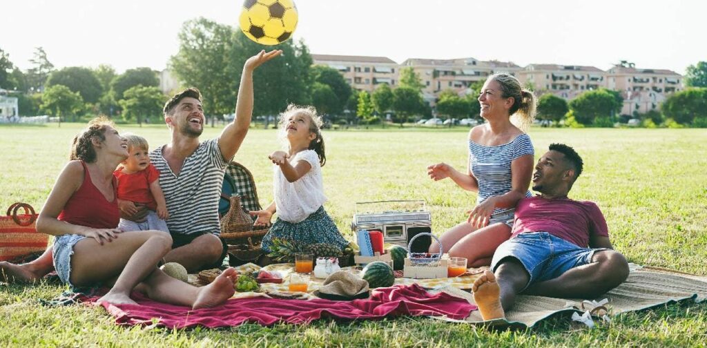 Happy families having fun doing picnic at park outdoor in summer vacation.