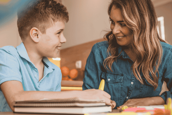 Female teaching assistant works with young boy