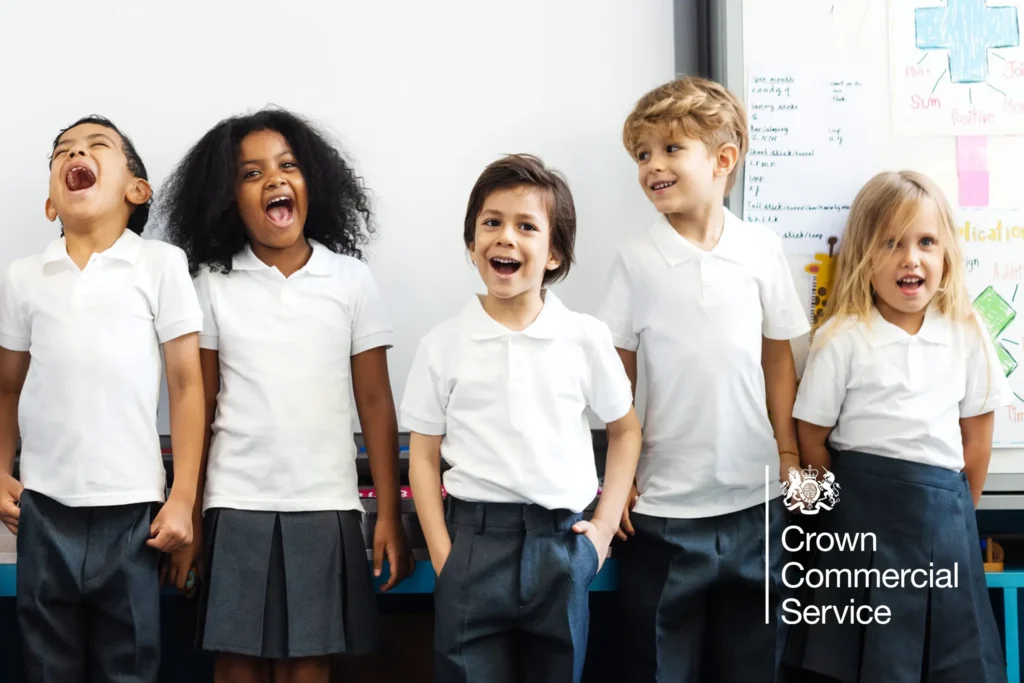 School kids lined up in front of whiteboard laughing