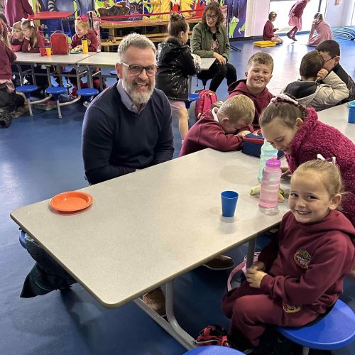 Paul sitting and eating breakfast with the kids