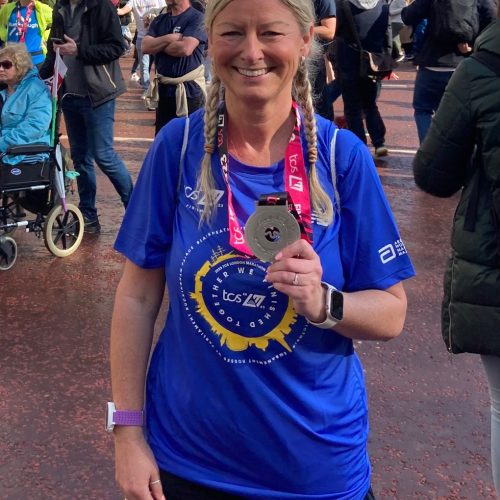 Gail holding medal from the London Marathon