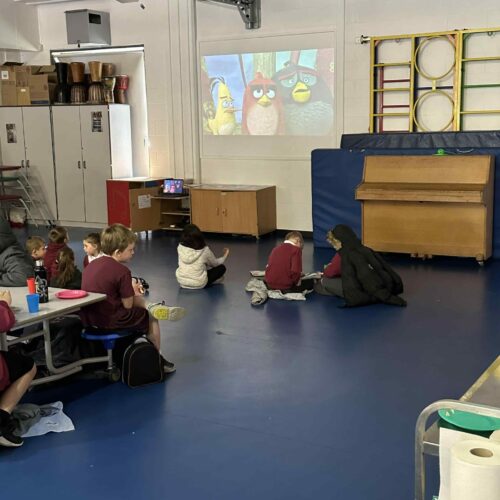 Kids watching a film during breakfast club